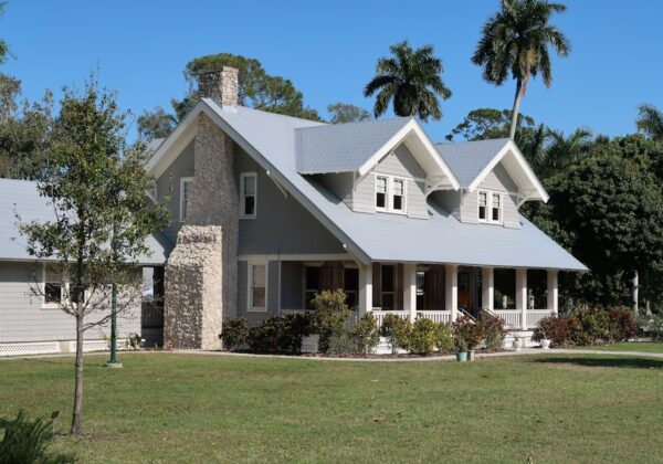 brown and white concrete house near green grass field during daytime