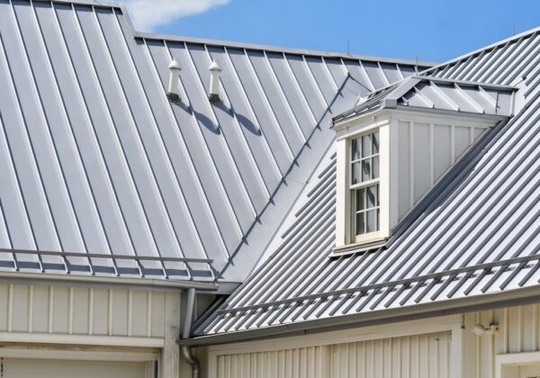 Grey metal roof, white siding, and a dormer window.