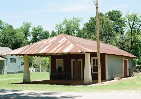 Old building with a rusty metal roof and porch.