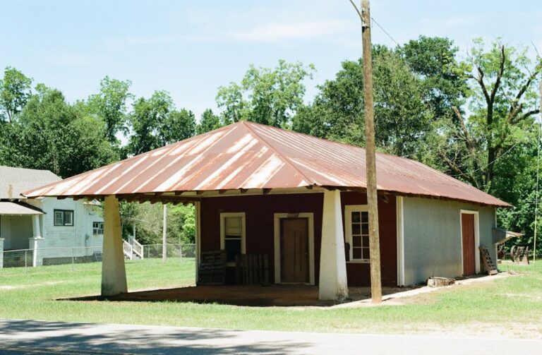 Old building with a rusty metal roof and porch.